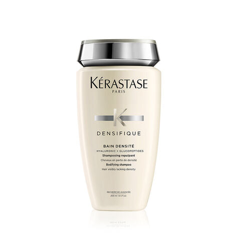 Bottle of Bain Densifique shampoo, cream in colour with white bg